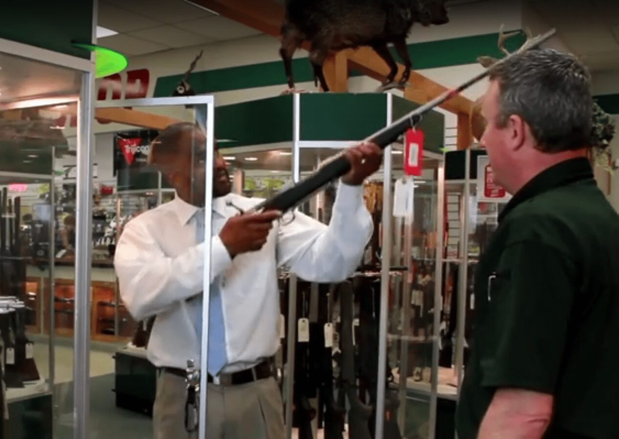 Salesman showing rifle to customer at H&H Shooting Sports in Oklahoma City