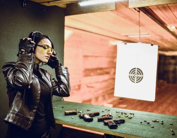 A woman putting on her noise-canceling earphones for the shooting range in Oklahoma